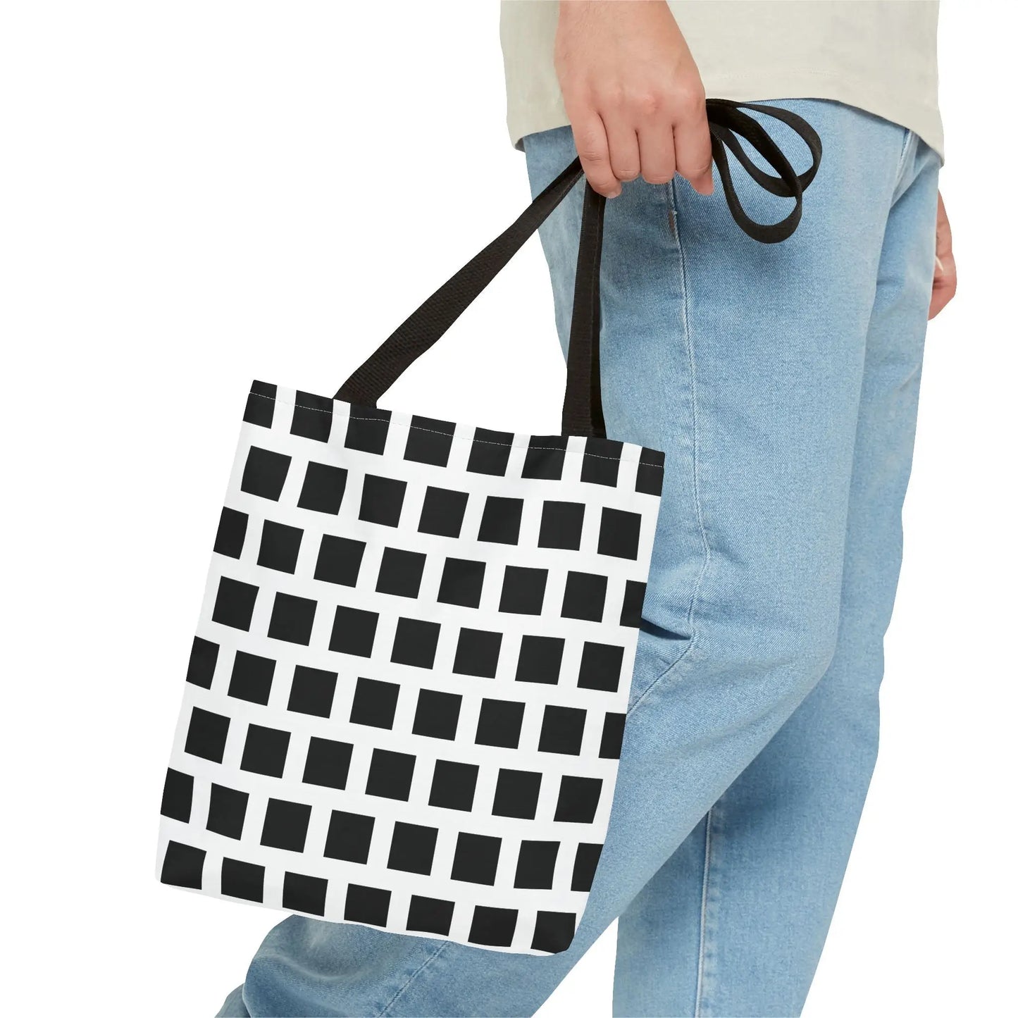 Black and white geometric canvas tote bag with black fabric handles featuring a black square pattern design