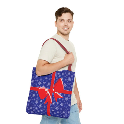 Blue christmas tote bag with white snowflake pattern and red bow perfect for holiday shopping and gift giving