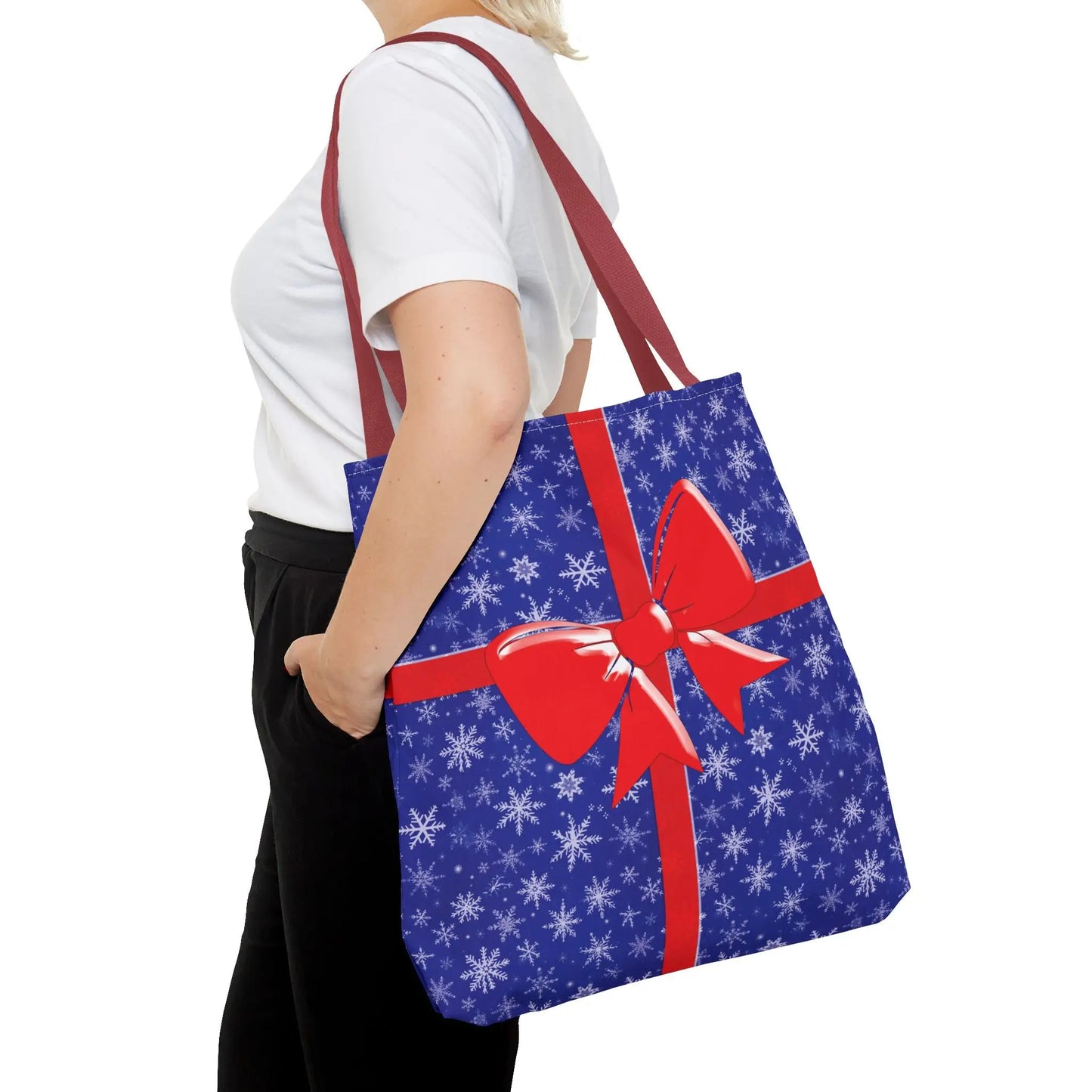 Blue christmas tote bag with white snowflake pattern and red ribbon bow for festive holiday shopping use