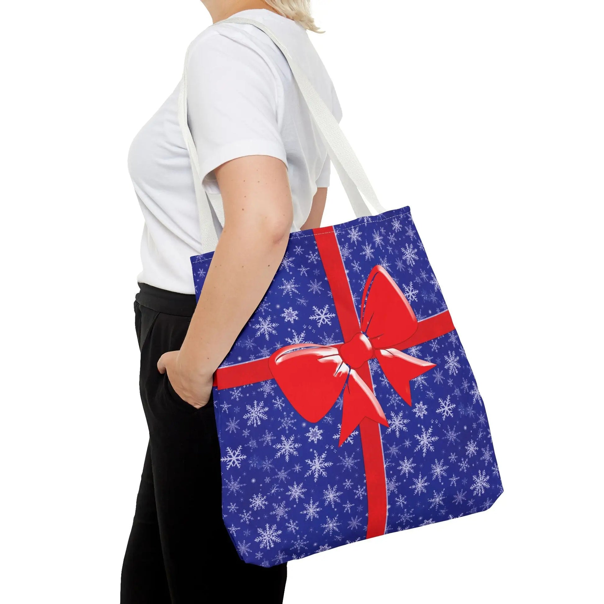 Blue christmas tote bag with white snowflakes red bow and white red blue handle options for holiday shopping
