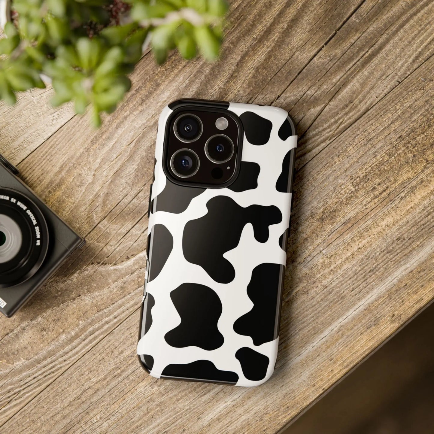 Back of a sleek black cow print phone case with glossy finish designed for iphone 13 pro protective cover