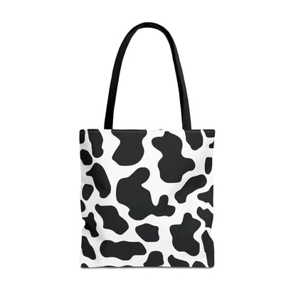 Large black and white cow print tote bag with black fabric handles for reusable shopping and travel use