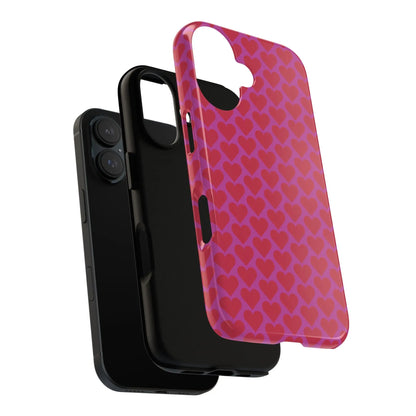 Back side of a vibrant pink heart pattern tough phone case with red hearts and precise cutouts for camera and buttons