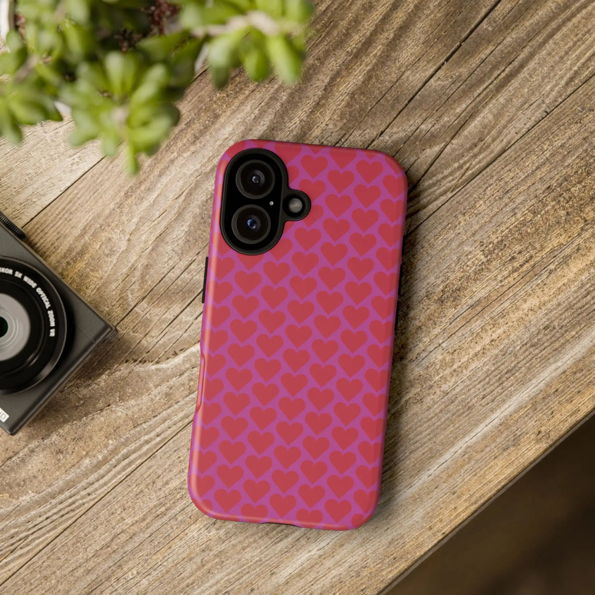 Back side of a vibrant pink heart pattern tough phone case with a repeating darker heart pattern for protective use