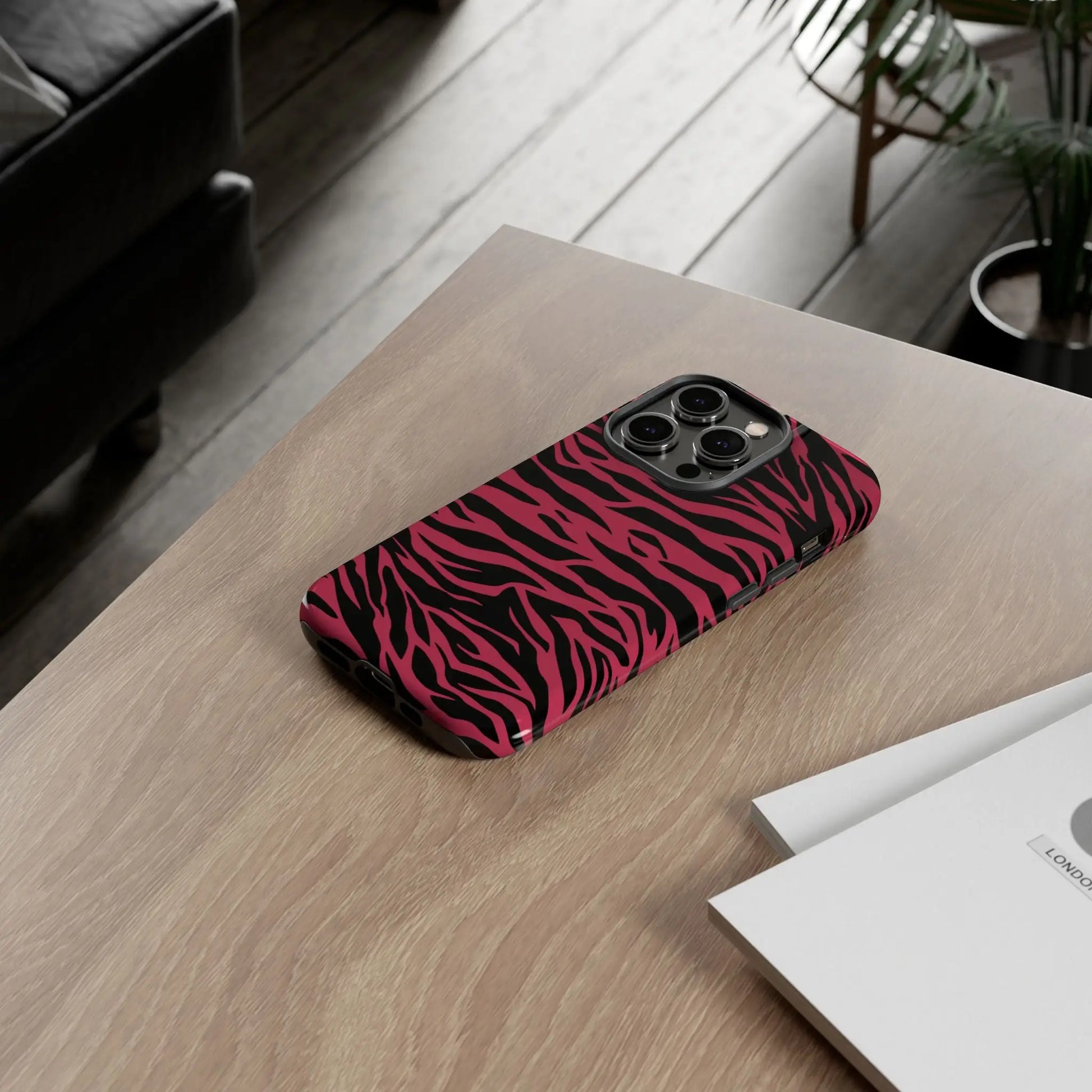 Back side of a vibrant magenta wild tiger pattern print phone case with glossy pink and black zebra stripes for iphone pro