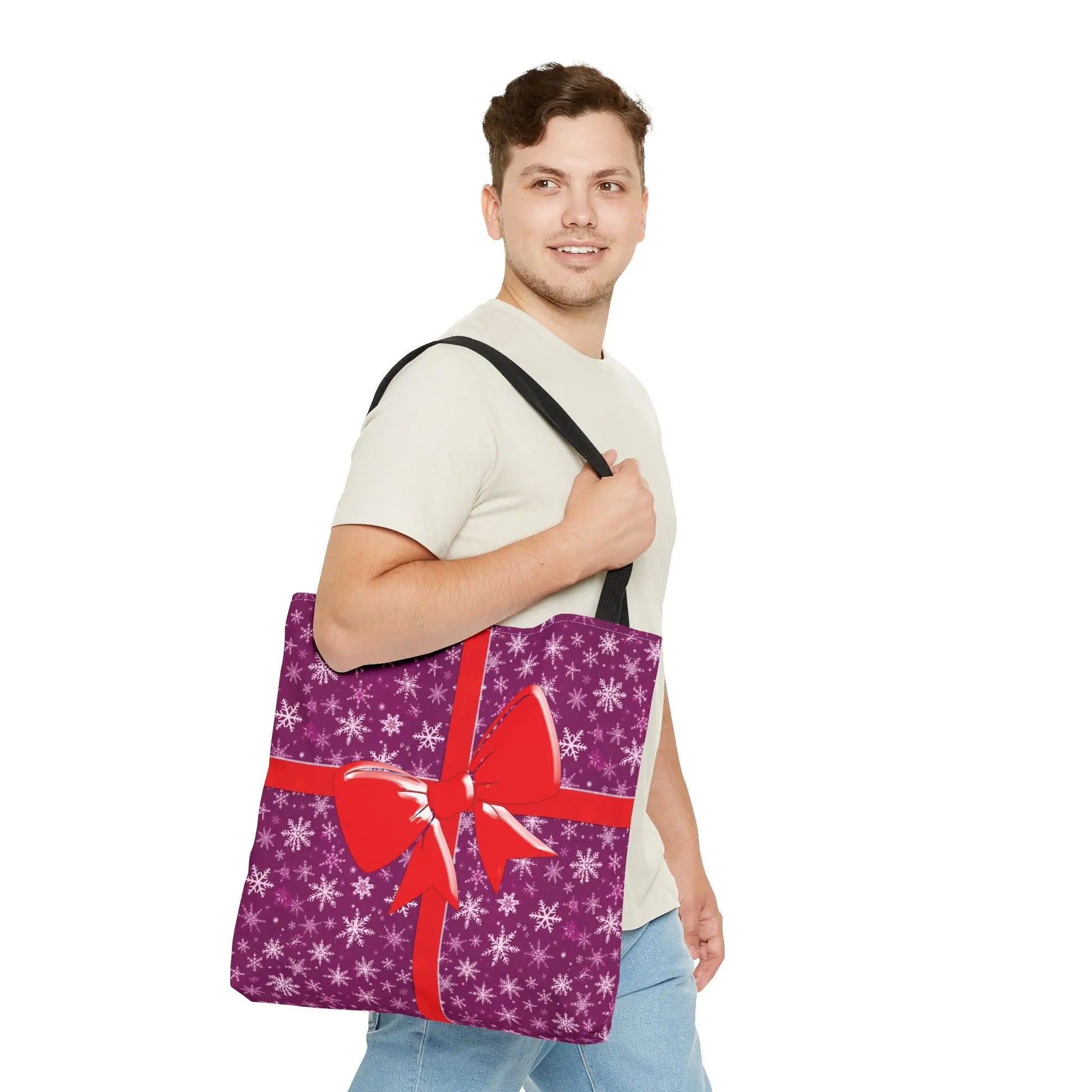 Pink christmas tote bag in purple with white snowflakes and a large red bow perfect for festive gift carrying