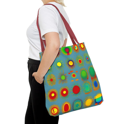 A vibrant blue sun pattern tote bag with colorful sunburst circles and contrasting maroon straps