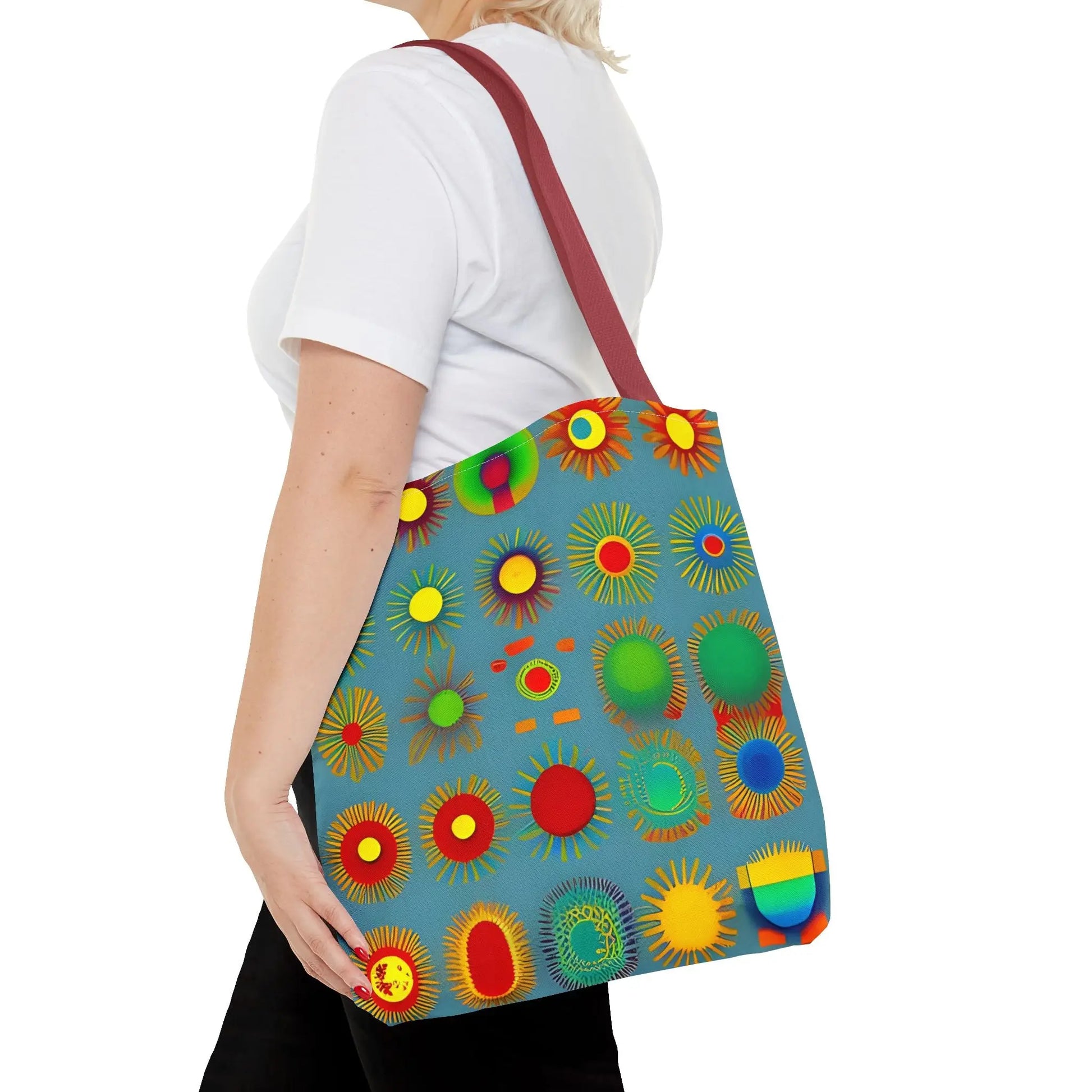 A vibrant blue canvas sun pattern tote bag with colorful sunburst circles in red green yellow and orange